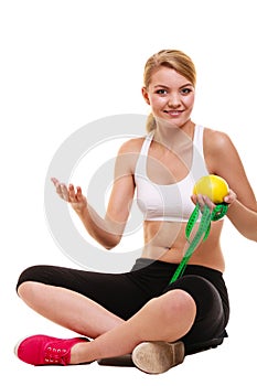 Joyful woman holds grapefruit and measurement tape