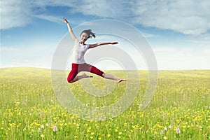 Joyful woman leaps at field in springtime