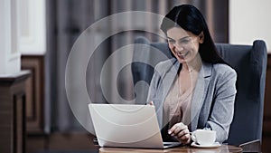 joyful woman looking at laptop in