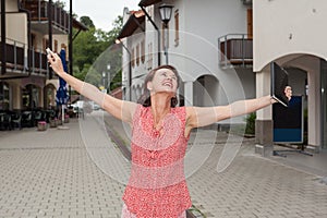 Joyful Woman with Open Arms on City Street