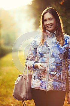 Joyful woman outdoors. Serenity and peace. Female handbag.