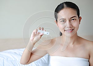 Joyful woman with positive pregnancy shown in the test device