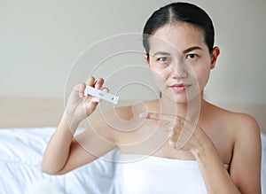 Joyful woman with positive pregnancy shown in the test device