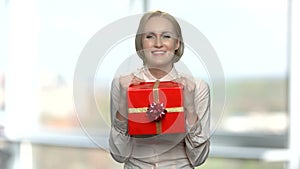 Joyful woman with red gift box.