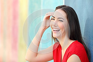 Joyful woman in red laughing looking at camera