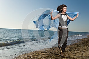 Joyful woman running at sea shore