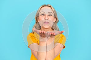 Joyful woman sending air kiss with open palms