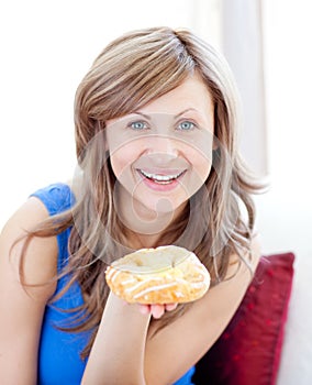 Joyful woman showing a danish pastry