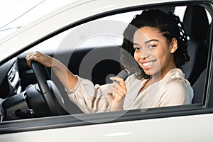 Joyful Woman Showing Key Sitting In Driver`s Seat In Automobile