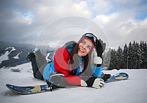 Joyful woman snowboarder in winter at ski resort