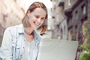 Joyful woman using laptop