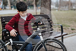 Joyful young boy taking a break from riding his bicycle in the park photo