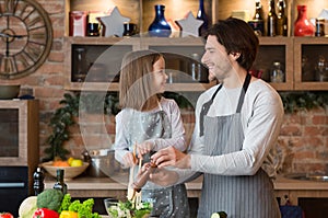 Joyful Young Dad And Little Daughter Cooking Vegetable Salad For Lunch Together