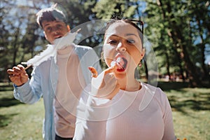 Joyful young friends enjoying cotton candy in a sunny park