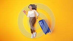 Joyful Young Globetrotter Lady With Suitcase And Tickets In Studio