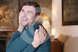 Joyful young man hugging himself