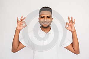 Joyful young man showing OK gestures with both hands