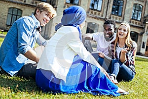 Joyful young people chatting outdoors together