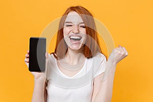 Joyful young redhead woman girl in white t-shirt posing isolated on yellow background. People lifestyle concept. Mock up