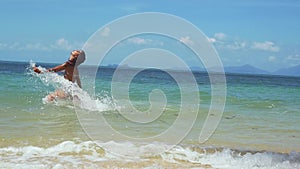 Joyful young woman in bikini running along the exotic beach swimming in the sea on sunny summer day. slow motion