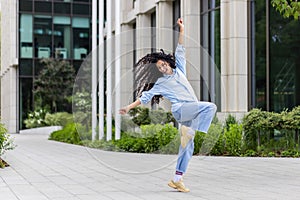 Joyful young woman dancing outdoors with a lively urban backdrop