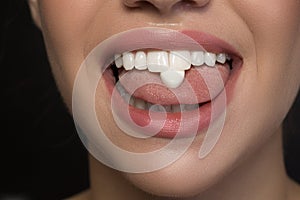 Joyful young woman is demonstrating chicle on her tongue