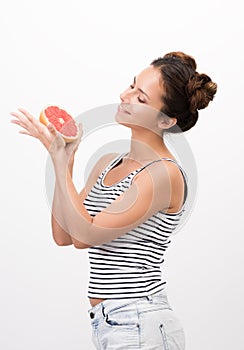 Joyful young woman holding a grapefruit. Healthy, natural food