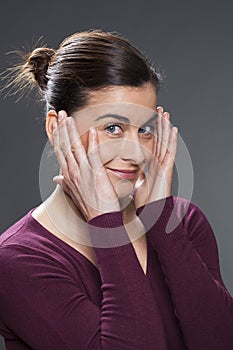 Joyful young woman massaging her temples for skin smoothing