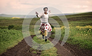 Joyful young woman running on a countryside road