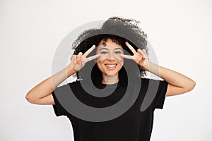 Joyful young woman showing V-signs near her eyes