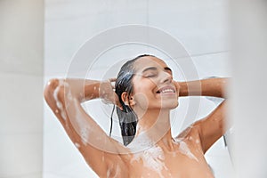 Joyful young woman taking shower in the morning at home
