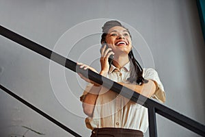 Joyous African American woman chatting on her smartphone