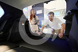 Joyous auto dealership client admiring automobile interior