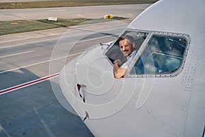 Joyous aviator posing for the camera from the flight deck