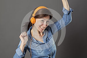 Joyous beautiful middle aged woman dancing in listening to music