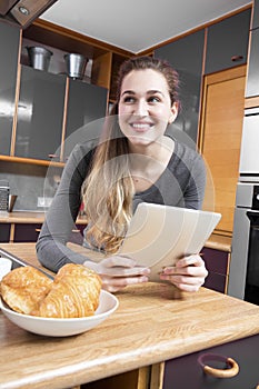 joyous beautiful young woman looking away from her morning messages photo