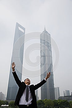 Joyous businessman with his arms raised