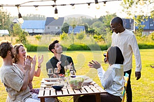 Joyous Celebration at a Garden Dinner Party as a Black Man Shares Good News