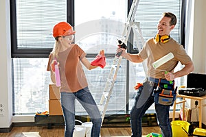 Joyous couple dancing, having fun after making repairs, painting walls in new home