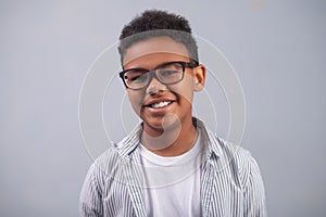 Joyous cute boy in eyeglasses posing for the camera