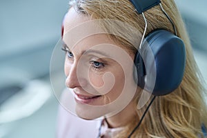 Joyous female patient daydreaming during a hearing screening procedure