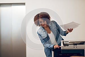 Joyous focused female secretary using the copy machine