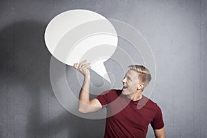 Joyous man holding empty speech balloon. photo