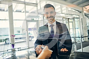 Joyous man holding travel documents smiling at the camera