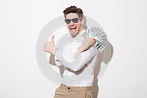 Joyous man in shirt and sunglasses rejoicing while demonstrating