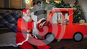 Joyous Santa Claus enjoying with modern gadget.