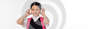 joyous schoolgirl in wireless headphones listening