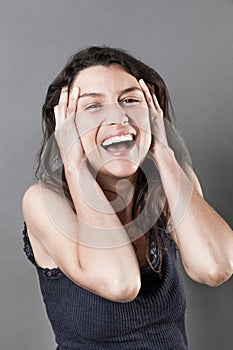 Joyous young woman bursting out laughing