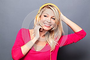 Joyous young woman listening to music on orange headphones