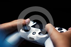 Joystick in game isolated in black. Close-up of hands holding gamepad in black background.
